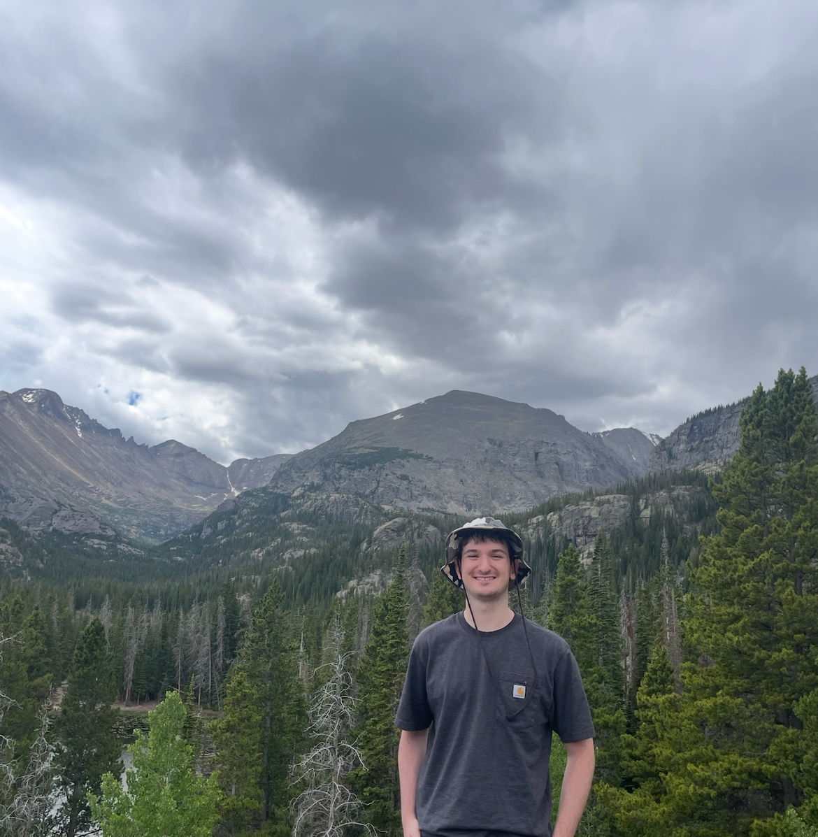 Mike DiBernardo hiking, with a mountain valley behind him